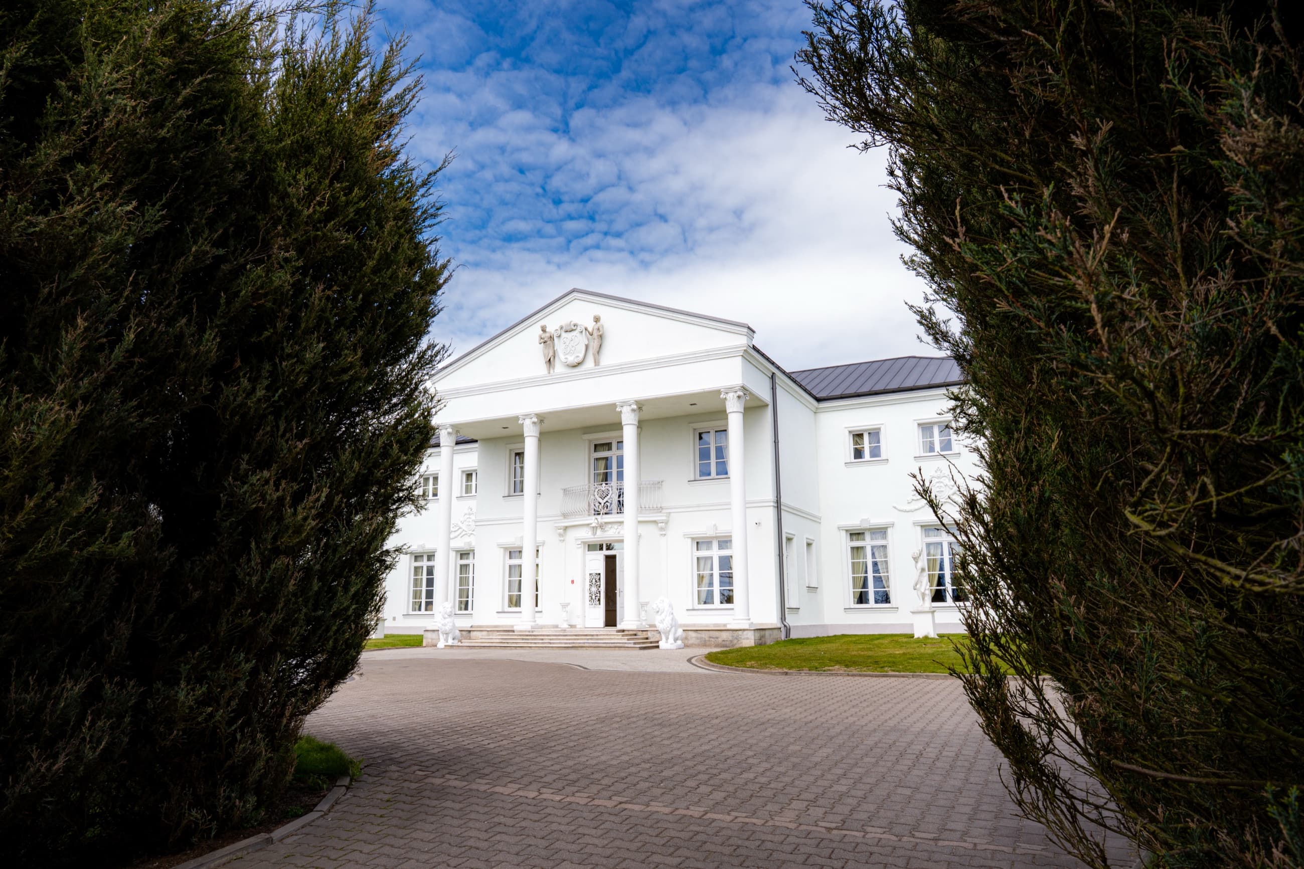 Fasada Białego Pałacu widziana przez zieleń